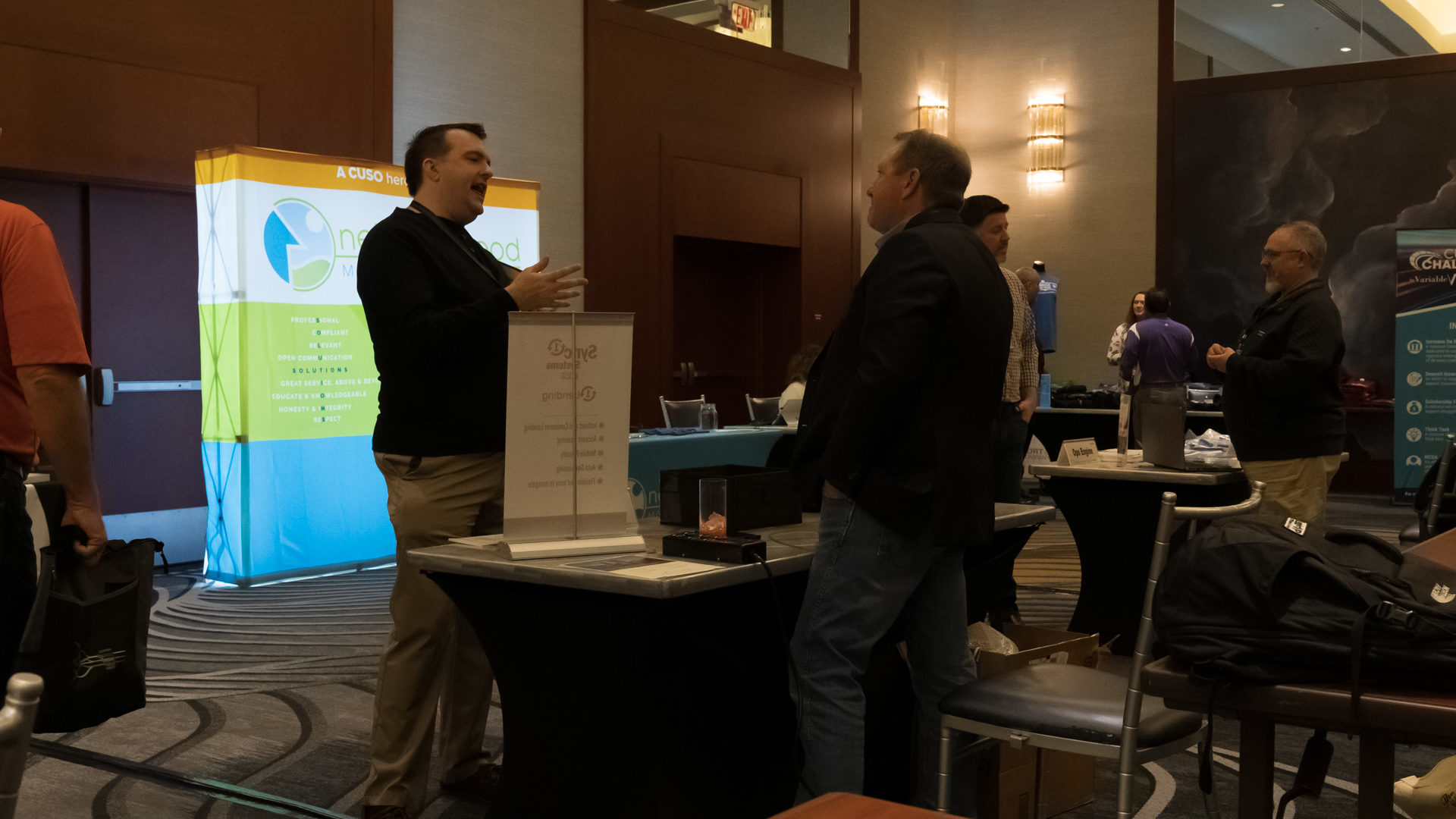 1st Street Credit Union President/CEO Arthur Hart engages in conversation with a representative from Sync1.