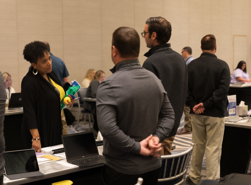 Attendees speak with vendors. 